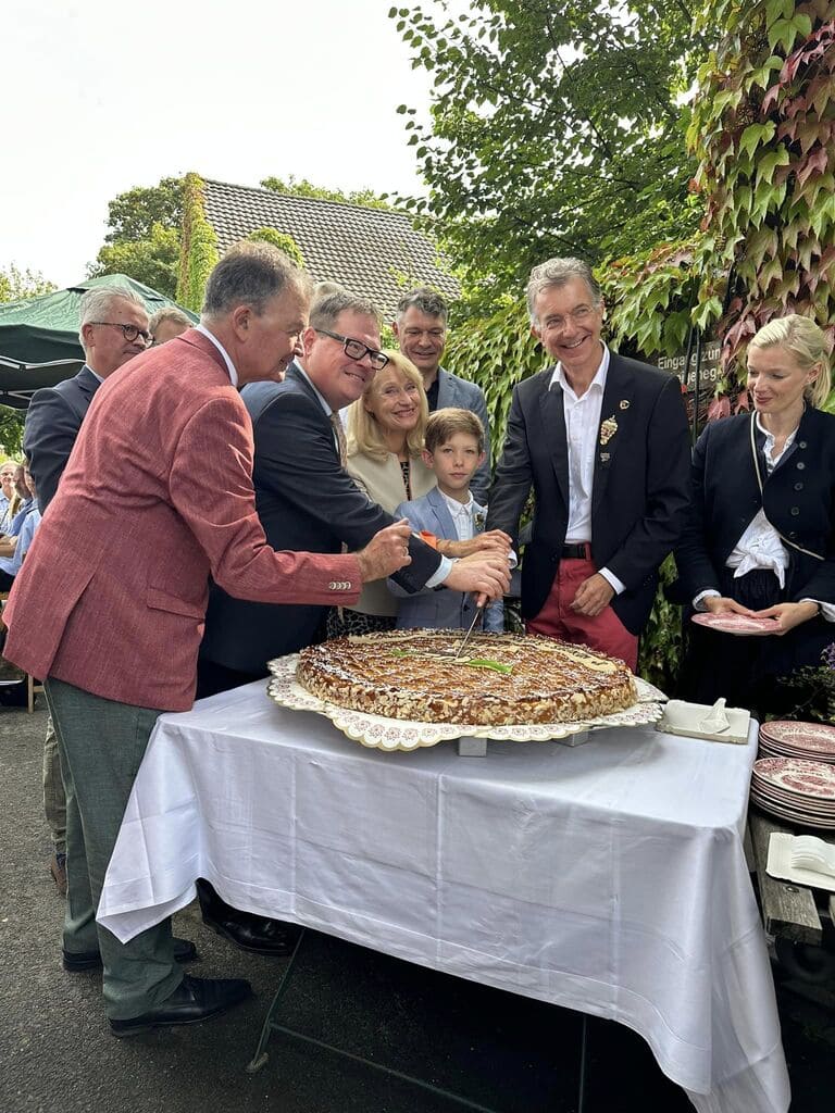 Appeltaatefest 2023 - Schützenkönig Christoph Heusgen (r.) schnitt mit Edelknabenkönig Samuel Appelfeller, Schützenpräsident Martin Flecken (l.) und Thomas Schommers als Gastgeber die Ehren-Appeltaate an.